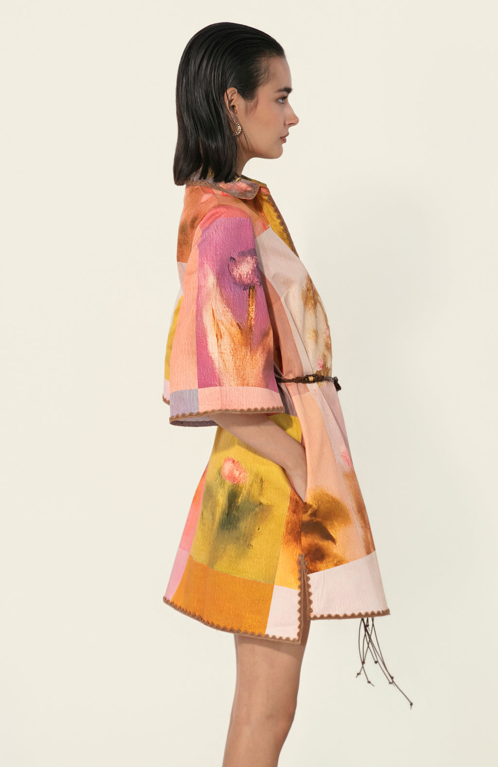 Model wearing a multicolor printed belted mini dress with wide sleeves from Thr3letter premium women's western wear collection.