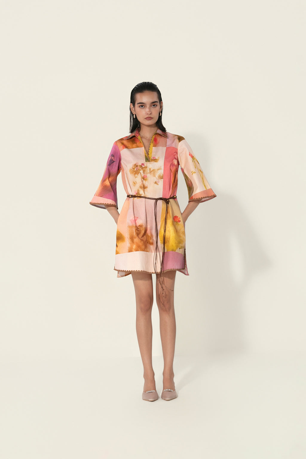 Model wearing a multicolor printed belted mini dress with wide sleeves from Thr3letter premium women's western wear collection.