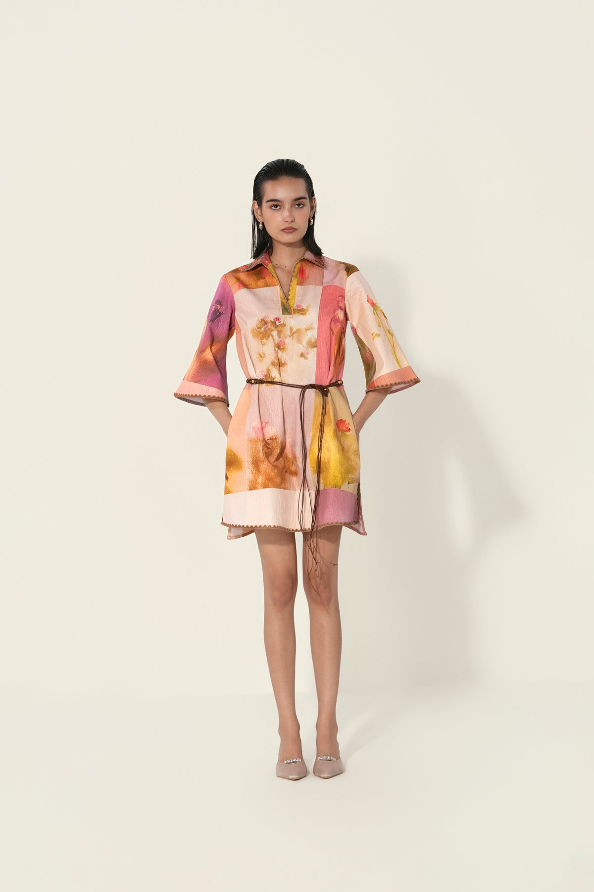 Model wearing a multicolor printed belted mini dress with wide sleeves from Thr3letter premium women's western wear collection.