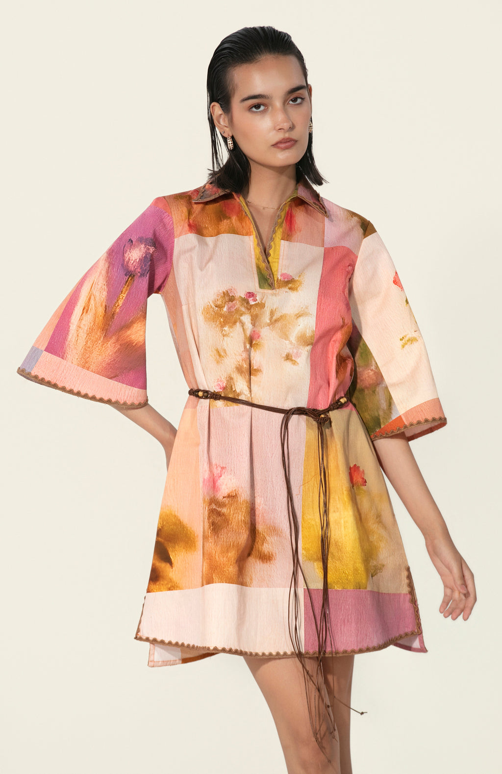 Model wearing a multicolor printed belted mini dress with wide sleeves from Thr3letter premium women's western wear collection.