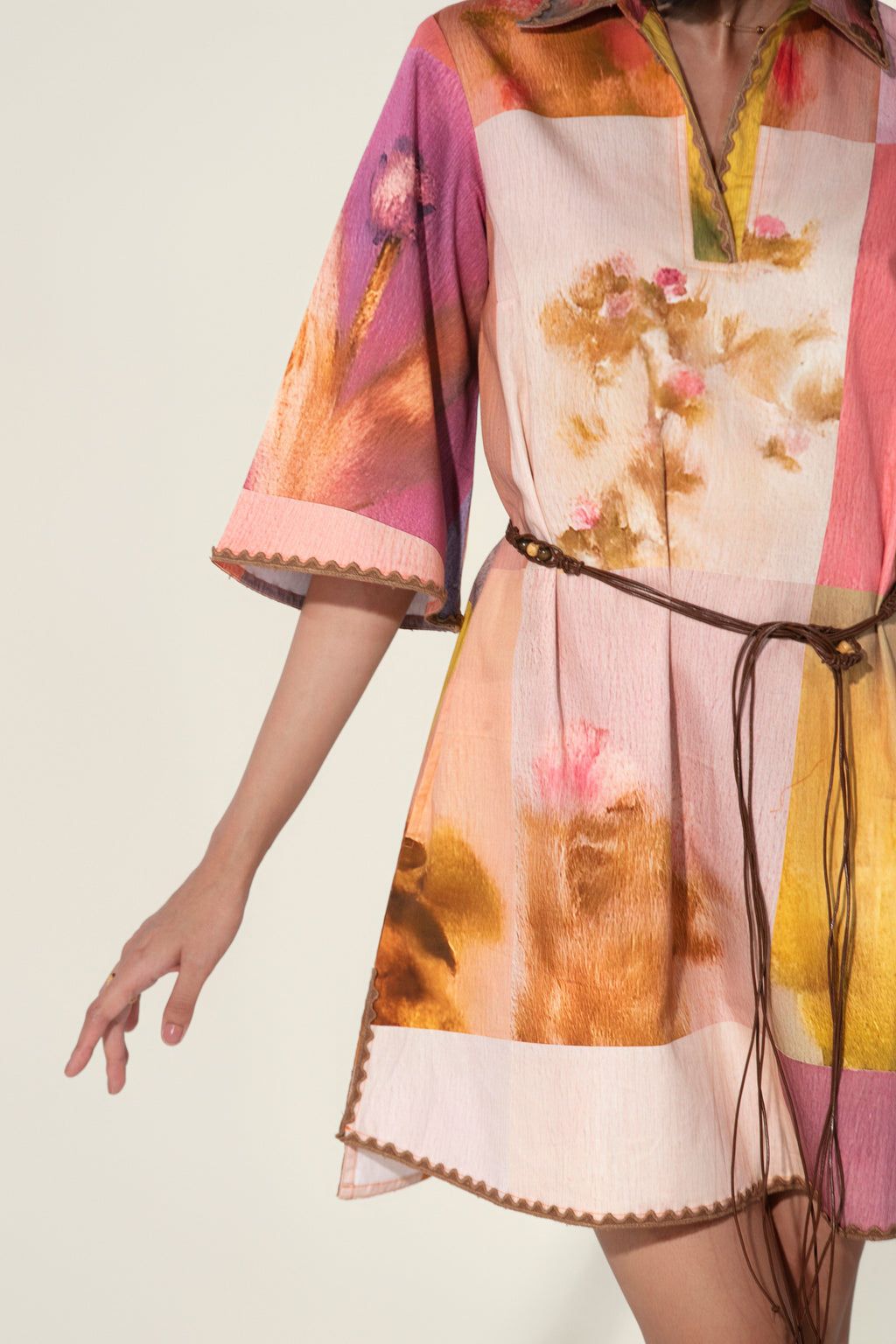 Model wearing a multicolor printed belted mini dress with wide sleeves from Thr3letter premium women's western wear collection.