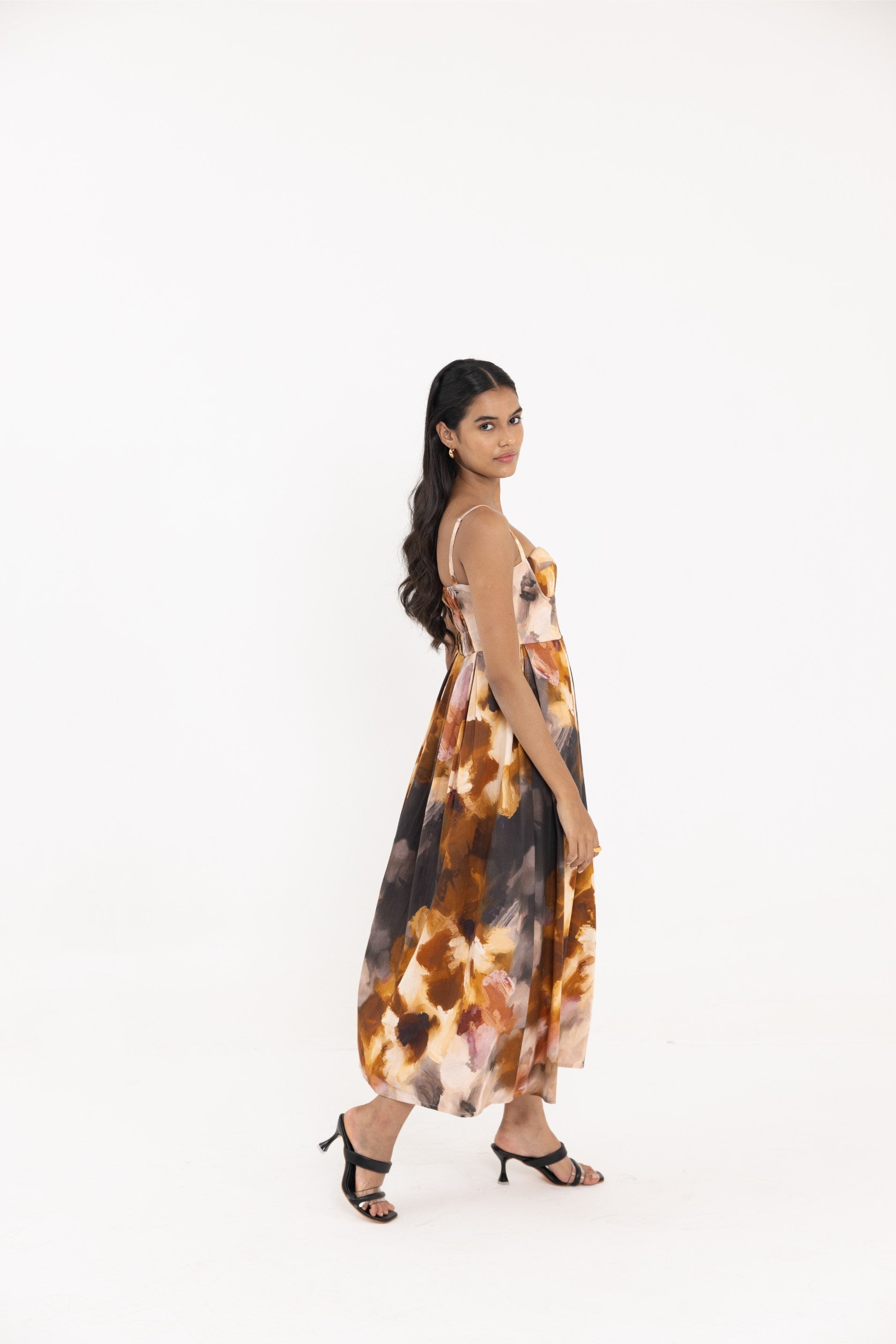 Thr3letter Yafa Padded Sleeveless Floral Gown - A long, sleeveless dress with a padded bodice and a vibrant floral print in shades of orange, yellow, and brown.