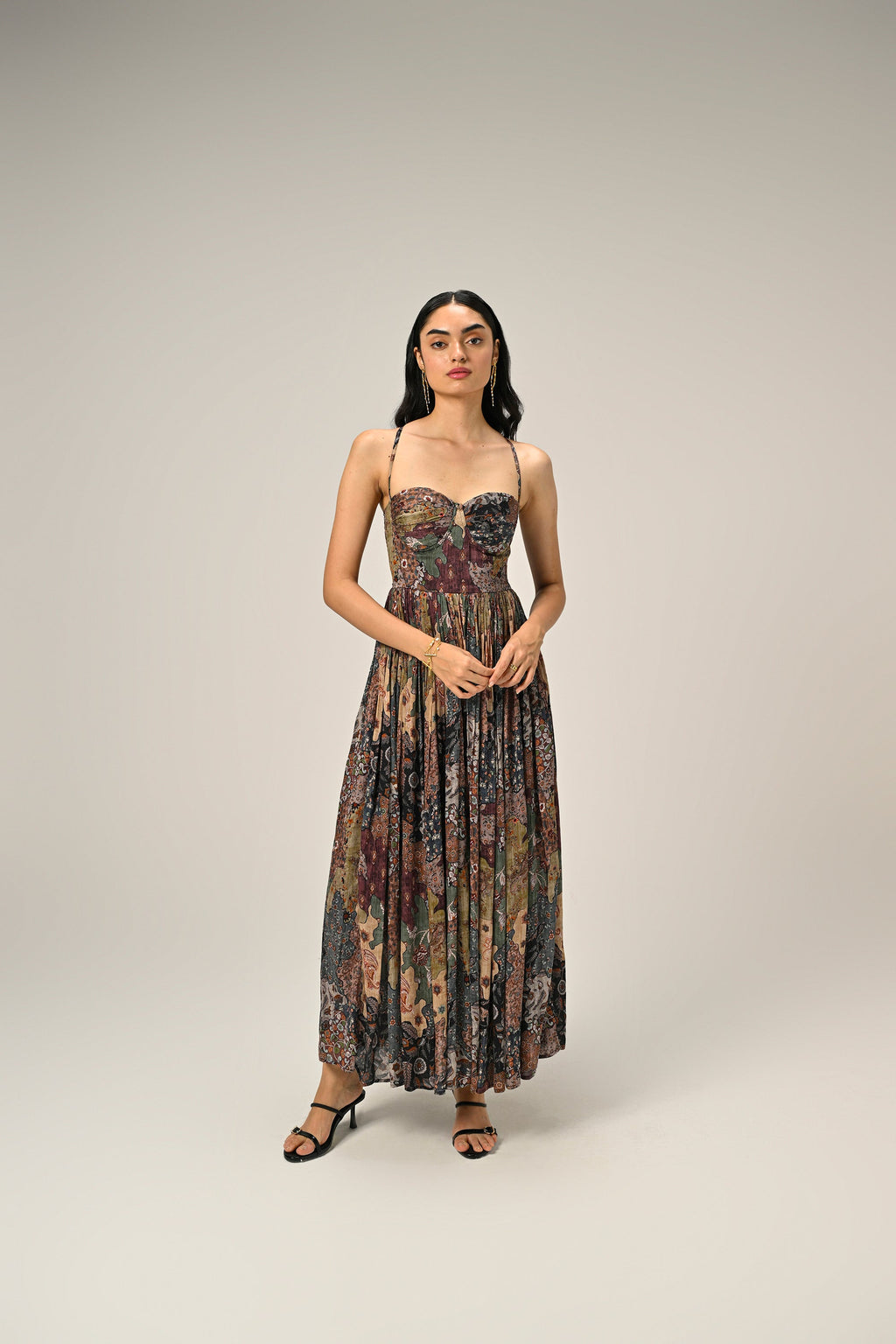 Model wearing a vintage-inspired paisley print bustier maxi dress with spaghetti straps and a flowing silhouette.