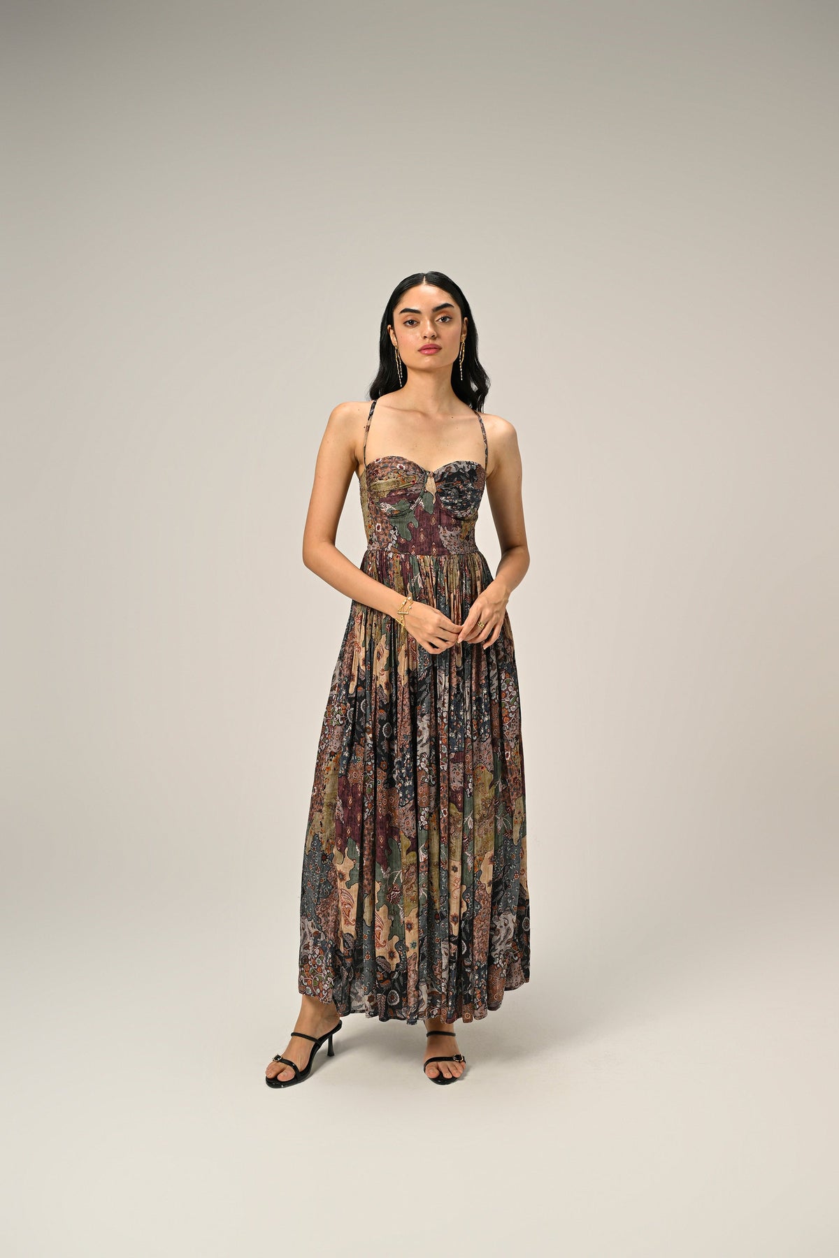 Model wearing a vintage-inspired paisley print bustier maxi dress with spaghetti straps and a flowing silhouette.